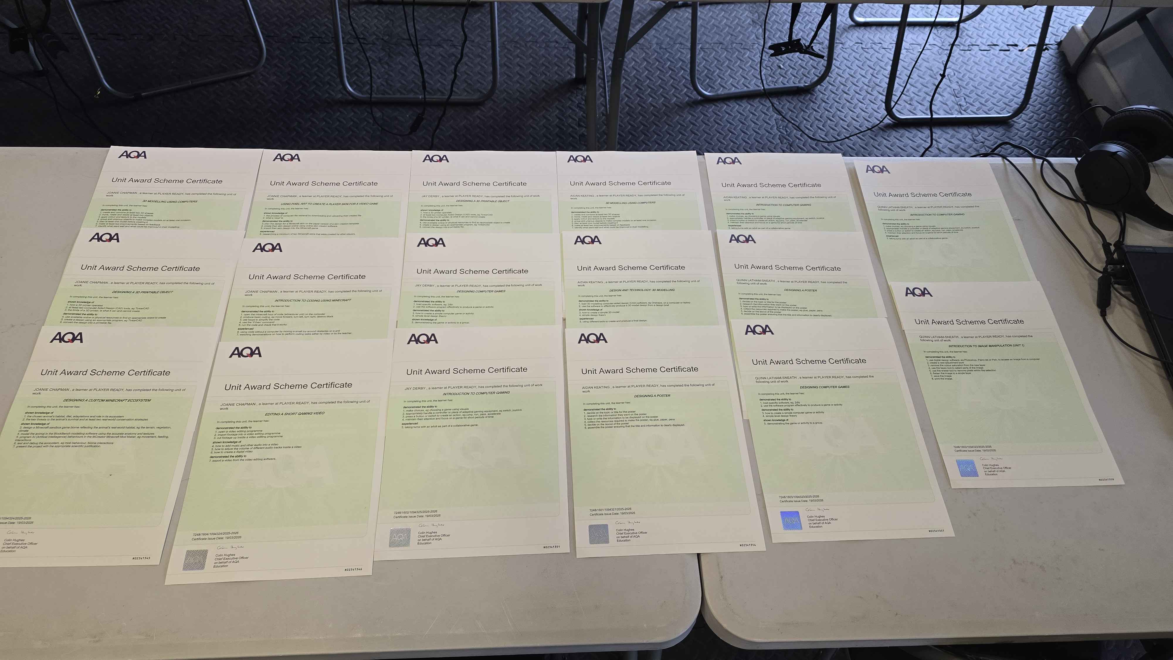 A fantastic collection of AQA Unit Award Scheme Certificates displayed on the table, showcasing student achievements across multiple qualifications. These certificates represent the hard work and dedication of students working through structured learning modules, particularly valuable for SEND students in alternative provision gaining recognized qualifications.
