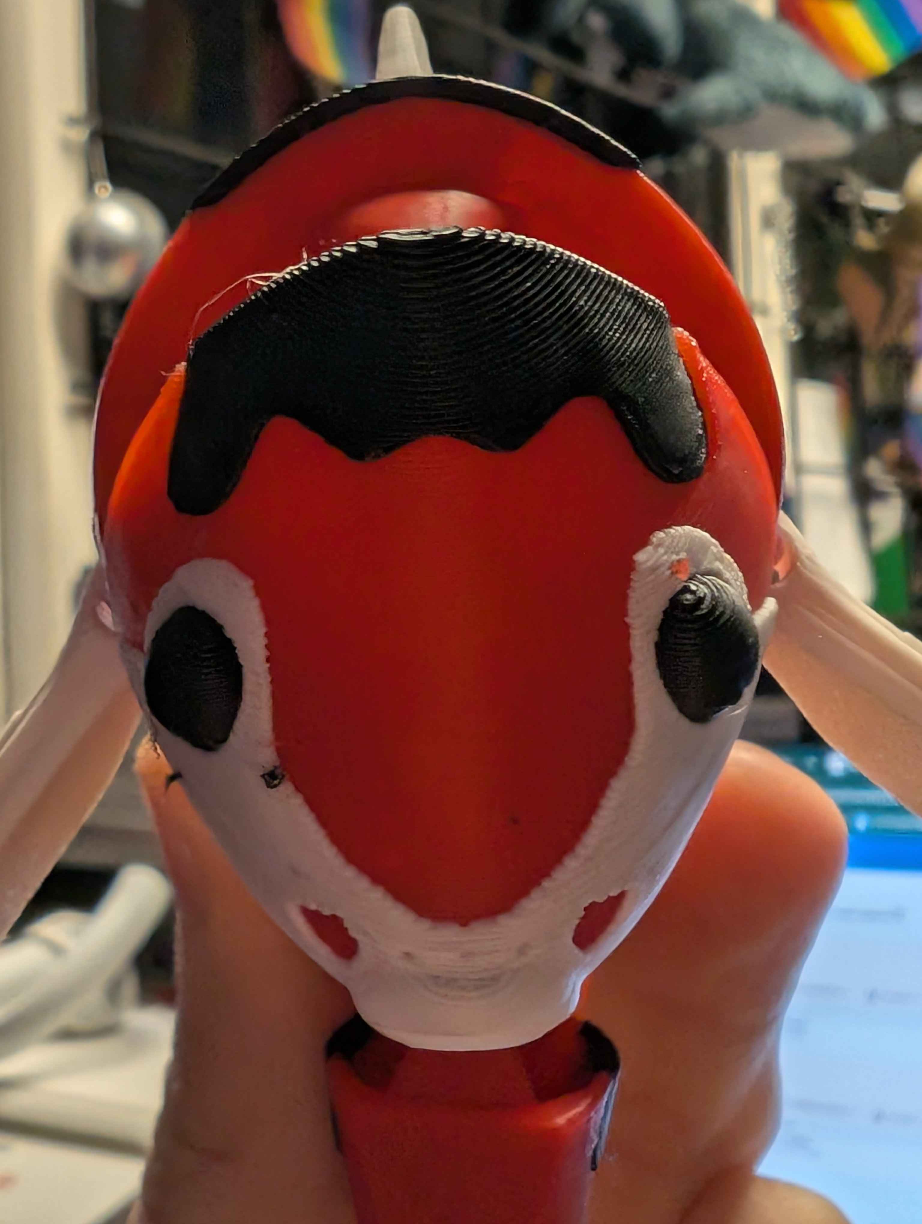 A creative 3D printed character design featuring vibrant red and black colors with distinctive hair styling. This student project showcases skills in 3D modeling and demonstrates understanding of multi-material printing techniques to achieve the contrasting color scheme.