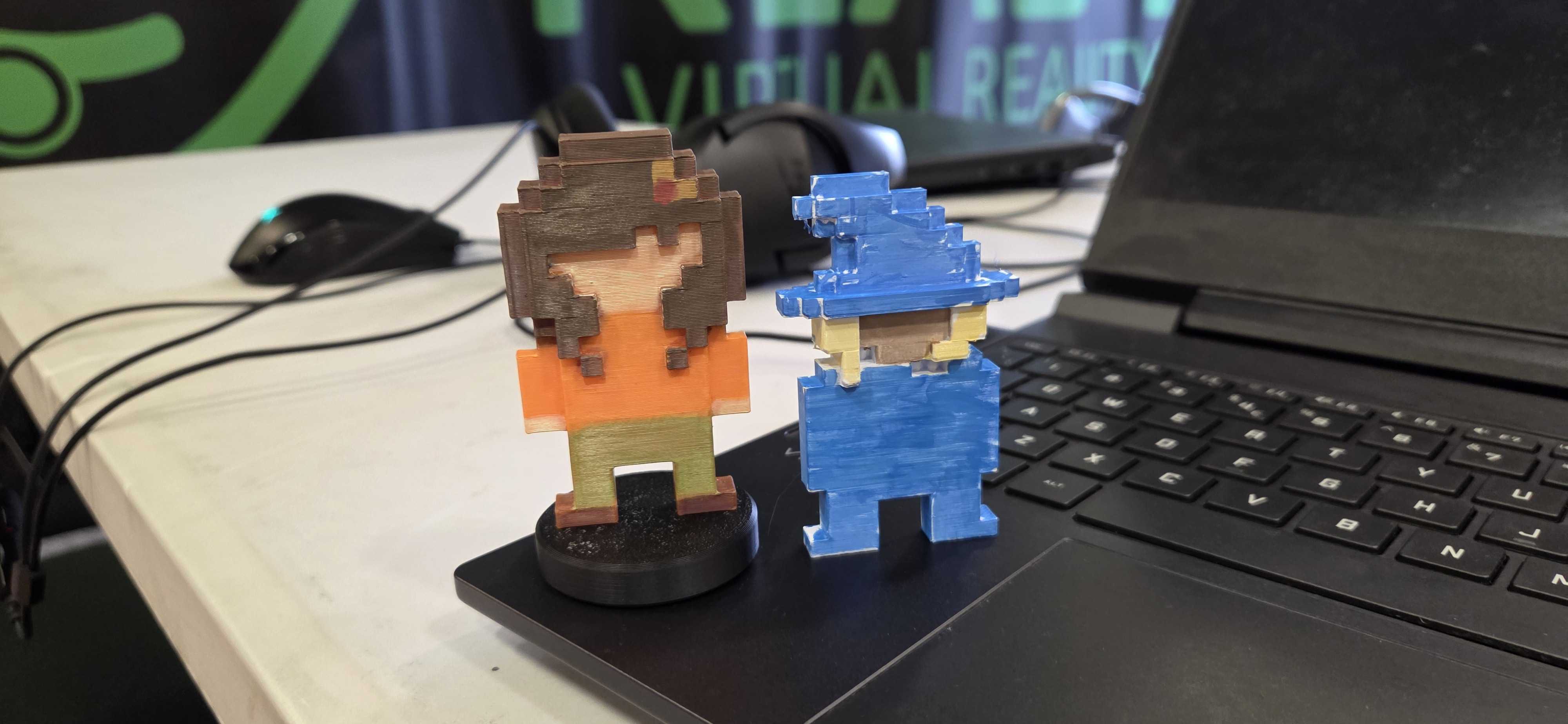 Fantastic 3D printed pixel art characters! These detailed figures showcase creative design skills and successful 3D printing, with one character in vibrant orange and green tones, and another in blue, both featuring classic retro gaming aesthetics.